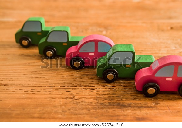 a lot, many wooden car toys stand\
in perspective line on wooden area. empty copy space for\
inscription or other objects . Eco, bio fuel sign, symbol and\
idea
