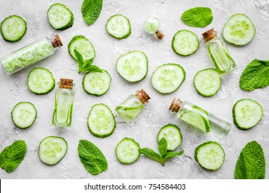 Lotion with cucumber pattern. Grey background top view.