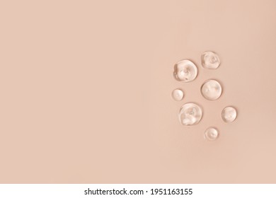 Lotion transparent gel drops texture background, Close-up drops transparent cosmetic aloe vera gel on neutral beige background with copy space. Body care and skin care, moistirize - Shutterstock ID 1951163155