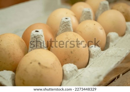 LOtok with eggs. An open tray with dirty eggs. eggs in the mud are not washed. Yellow domestic eggs.