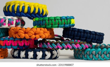 Lots of braided paracord bracelets on a white background. Handmade, creative design. - Shutterstock ID 2311988807