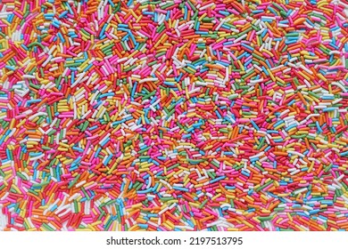 Lots of brightly colored sugar granules background used for topping desserts, cupcakes and ice cream in Top View It's a colorful background suitable for designs and has Copy Space to insert text 