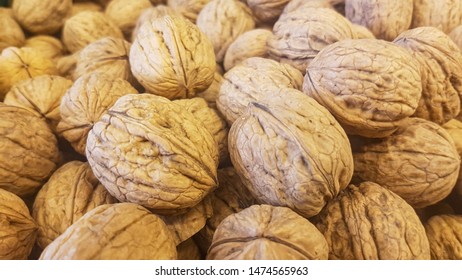 lots of brown inshell walnuts texture at the fresh vegan market