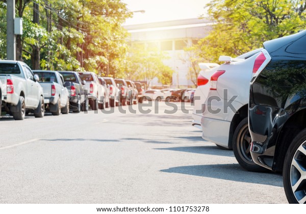 A lots of cars parked in the parking, Car\
on the road made of asphalt with\
sunlight.