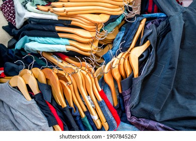 Lots of clothes on hangers piled in a pile. Heap of used clothes. Second hand for recycling