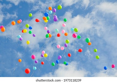 Lots Of Colorful Balloons Flying Against Blue Sky With Clouds With Copy Space. Concept Of Holiday, Children's Day, Last Call At School And Kindergarten, Birthday.