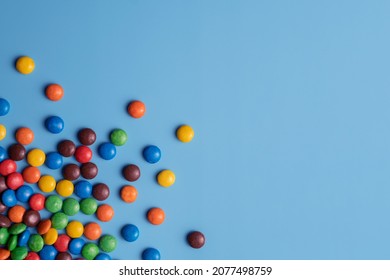 Lots Of Colorful Smarties Sweets On Blue Isolated Background. Color Close Up Studio Photo For Background.