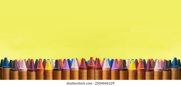 lots of crayons arranged in full space has a yellow background - Powered by Shutterstock