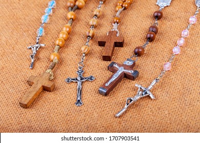 Lots Of Different Styled Christian Crosses, Multiple Rosaries Laying On Brown Background Prayer And Belief, Christianity Symbols Abstract Concept, Group Chaplet Of Divine Mercy, Rosary Prayer Symbolic