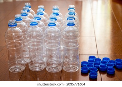 Lots of empty plastic bottles and caps on the wooden flooring