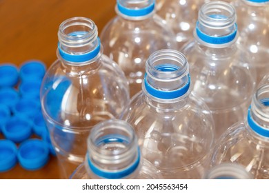 Lots of empty plastic bottles and caps on the wooden flooring