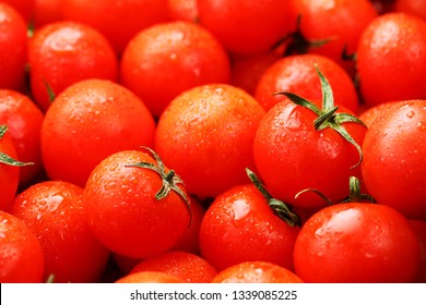 Lots of fresh ripe tomatoes with drops of dew. Close-up background with texture of red hearts with green tails. Fresh cherry tomatoes with green leaves. Background red tomatoes. Group of juicy ripe fr - Powered by Shutterstock