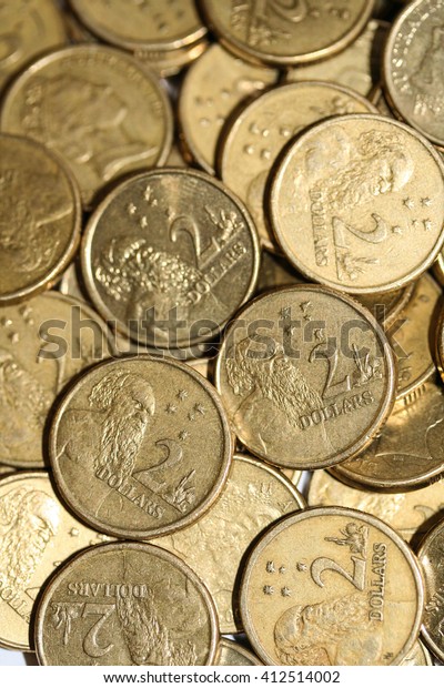 Lots of gold Australian two dollar coins with\
aborigine male stamped\
scattered.