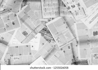 Lots of old newspapers on horizontal surface. Background texture, top view, blurred                      
