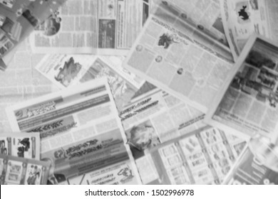 Lots of old newspapers on horizontal surface. Background texture, top view, blurred                     
