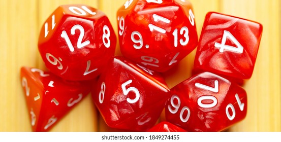 Lots of red RPG game dice extreme closeup wide shot, banner. Role playing board games symbol, simple polyhedral dice set scattered, showing random numbers. Nerd, geek culture, math probability concept