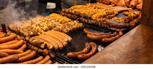Lots of tasty juicy meat, bbq, outdoors grill, sausages, shahlik, steam over hot grilled food, high resolution, wide shot, panoramic, warm colors. Traditional street food market stall closeup, nobody