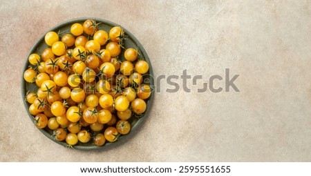 Lots of tiny yellow cherry tomatoes, top view, horizontal shot.