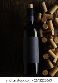 Lots Of Wine Corks And A Bottle Of Red Wine. Isolated On Black Background. There Are No People In The Photo. There Is Free Space To Insert. Bar, Restaurant, Hotel, Wine Cellar. Advertising.