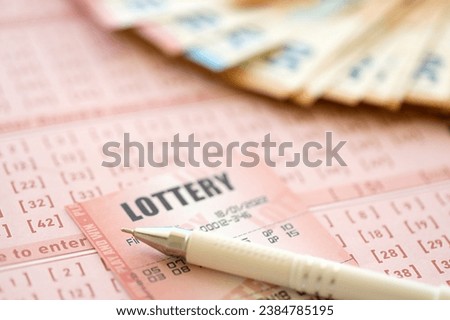 Lottery ticket and gambling receipt on table with pen and European Union euro money bills close up