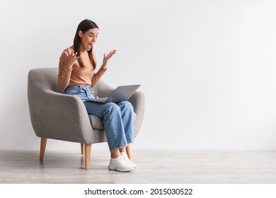 Lottery win, good luck, success, amazing online sale. Emotional young woman sitting in armchair with laptop, looking at screen, shouting in excitement, winning huge casino bet, copy space