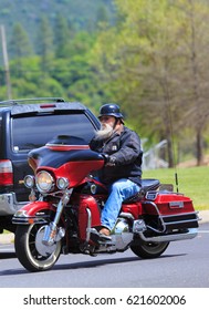 LOTTUS, CALIFORNIA, USA - APR 15, 2017: Older Man With A White Beard Riding His Red Hallie Davison Motorcycle 