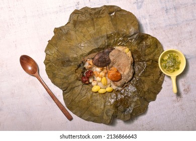 Lotus leaf rice isolated on wood table close up, top view, Chinese cultural food concept.