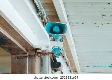 A loudspeaker mounted on a metal ceiling, commonly found on a ship. - Powered by Shutterstock