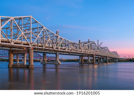 Louisville, Kentucky, USA with John F. Kennedy Memorial Bridge spanning the Ohio River at dusk.