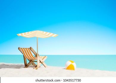 Lounge chair with parasol and beach ball on the coast, sky with copy space - Powered by Shutterstock