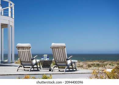Lounge chairs on patio overlooking ocean
