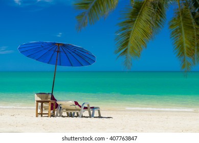  Lounge Chairs With Sun Umbrella On The Tropical  Beach