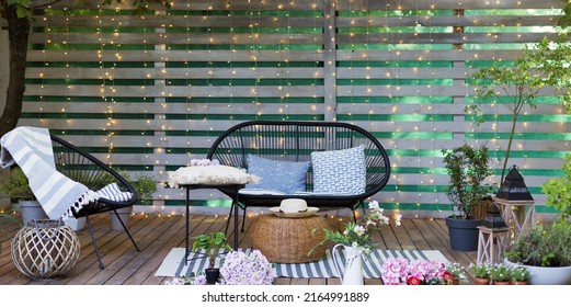 Lounge garden furniture at backyard. Black sofa and chair with pillows and blanket at the garden patio. - Shutterstock ID 2164991889