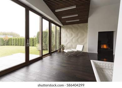 Lounge Room With Fireplace, Chair, Wood Floor And Garden View