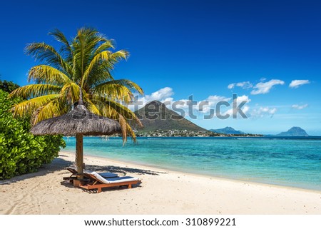 Loungers and umbrella on tropical beach in Mauritius Island, Indian Ocean