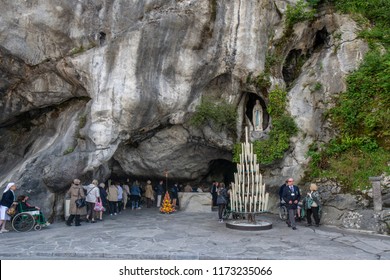 Lourdes, France; August 2013: The rock cave at Massabielle with the statue of the Virgin Mary where Saint Bernadette Soubirous claimed to have witnessed Marian apparitions 