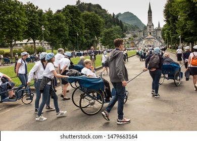 Lourdes, France June 24, 2019: Volunteers helping the sick get to the sanctuary of Our Lady in Lourdes, famous for many healings.