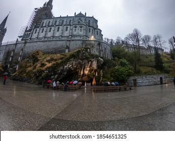 Lourdes / France - March 12, 2020: The Grotto of Massabielle is the place where the Virgin appeared to Bernadette Soubirous, a 14-year-old girl, in 1858. At the back left of the Grotto is the Spring.