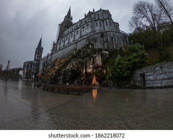 Lourdes, France - March 12, 2020: The Grotto of Massabielle is the place where the Virgin appeared to Bernadette Soubirous, a 14-year-old girl, in 1858. At the back left of the Grotto is the Spring.