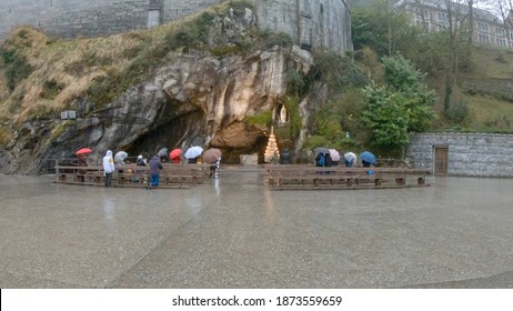 Lourdes, France - March 12, 2020: The Grotto of Massabielle is the place where the Virgin appeared to Bernadette Soubirous, a 14-year-old girl, in 1858. At the back left of the Grotto is the Spring.