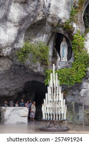 LOURDES - JULY 23, 2014: Candles displayed at the cave at Massabielle in Lourdes, where St. Bernadette Soubirous claimed to have seen the Blessed Virgin Mary. It now is a religious grotto.