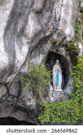 LOURDES - JULY 23, 2014: The rock cave at Massabielle with the statue of the Virgin Mary where Saint Bernadette Soubirous claimed to have witnessed Marian apparitions from the Blessed Virgin Mary.