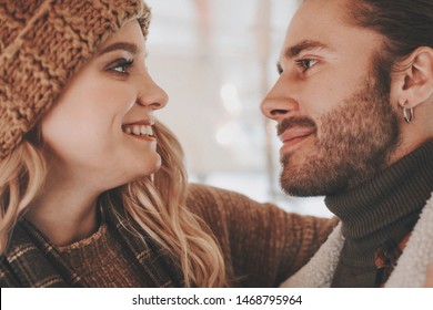 Love is in the air. Close up portrait of happy smiling woman embracing her beloved bearded male and they looking with love and tender to each other