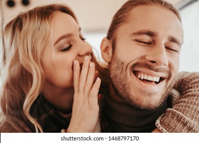 Love Is In The Air. Close Up Portrait Of Happy Woman Whispering On Ear Something Pleasant To Her Beloved Laughing Hipster Man While Embracing Him