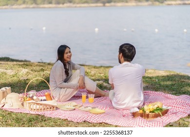  In love asian couple enjoying picnic time in park outdoors Picnic. happy couple relaxing together with picnic Basket. - Powered by Shutterstock