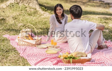  In love asian couple enjoying picnic time in park outdoors Picnic. happy couple relaxing together with picnic Basket.