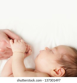 Love - baby holding fathers hand, white background