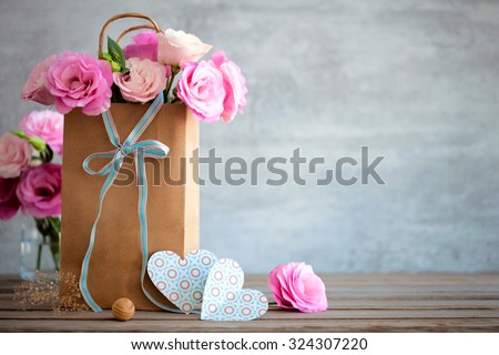 Love background with pink roses flowers, bow and paper handmade hearts
