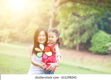 Love Between Mother And Daughter. Asian Family Outdoor Fun, Morning With Sun Flare.