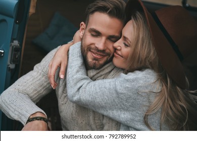 Love is the biggest treasure.  Beautiful young couple embracing and smiling while sitting in retro style mini van - Powered by Shutterstock